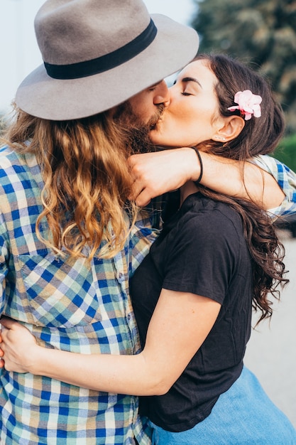 Young beautiful happy couple outdoor hugging french kissing