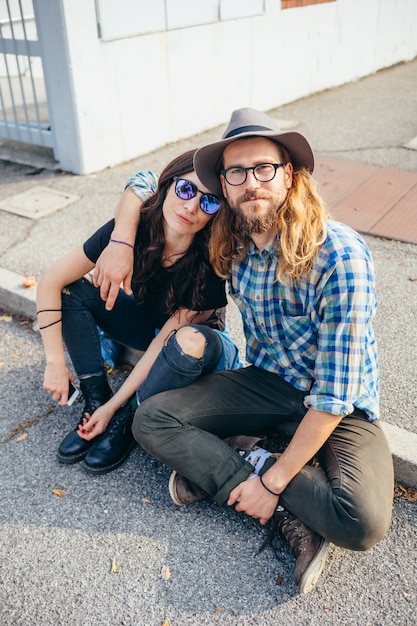 Young beautiful happy couple sitting outdoor posing hugging