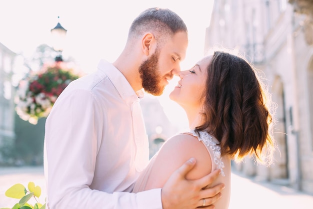 Young beautiful happy smiling couple posing on the street of the old city The models hug and look at each other