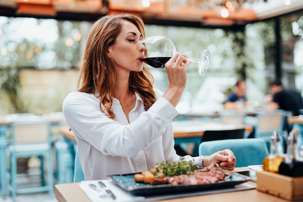 Young beautiful and happy woman enjoying in delicious meal in luxurious restaurant.