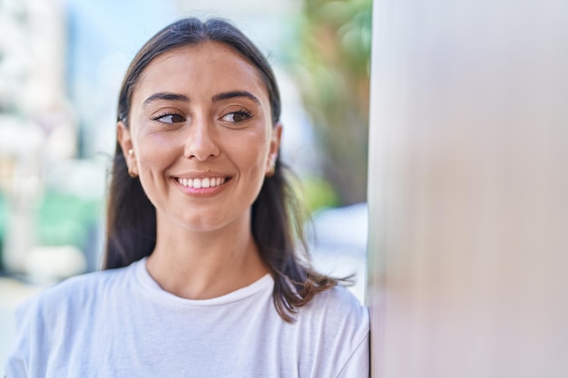 Young beautiful hispanic woman smiling confident looking to the side at street