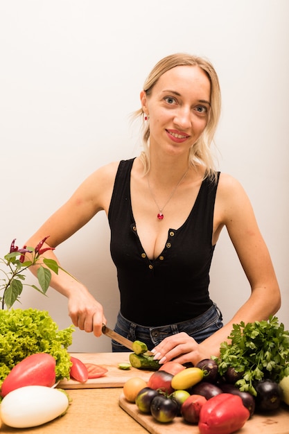 Young beautiful housewife is busy preparing healthy food at home in the kitchen