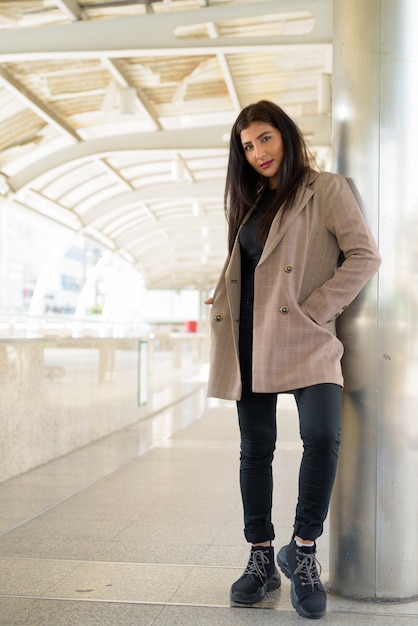 young beautiful Indian businesswoman at footbridge in the city