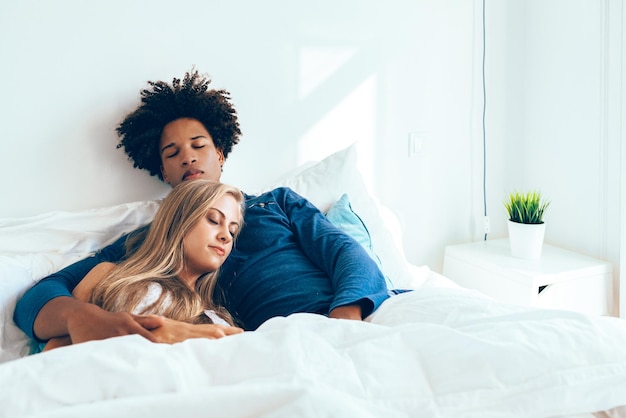 Young beautiful interracial couple in bed sleeping