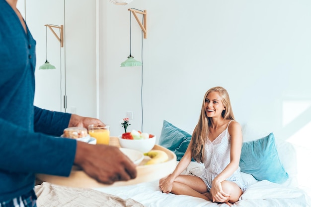 Young beautiful interracial couple having a surprise breakfast in bed xA