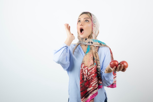 Young beautiful model in colorful shawl posing with red apples