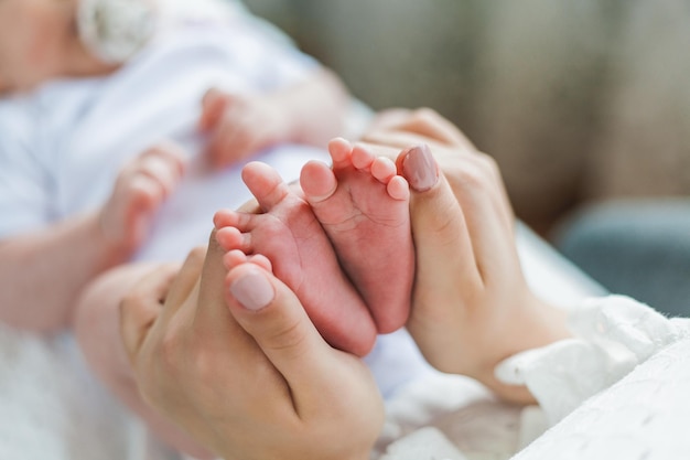 Young beautiful mother with blue eyes holds her little newborn daughter in her arms Motherhood Care Baby