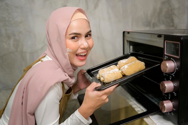 Young beautiful muslim woman is baking in her kitchen bakery and coffee shop business