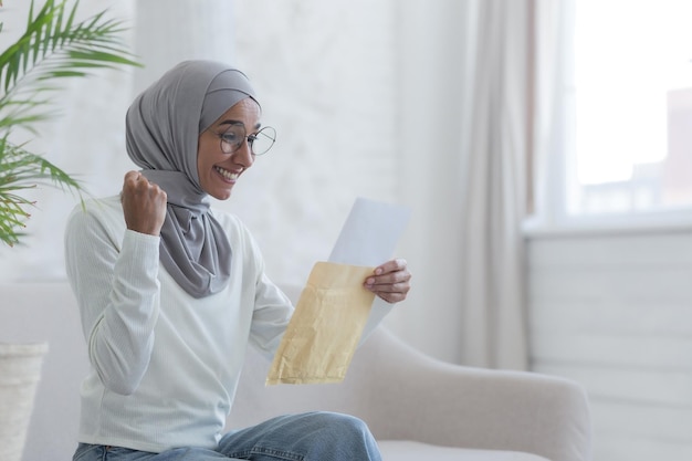 A young beautiful muslim woman reads a happy letter home arab student received confirmation from the