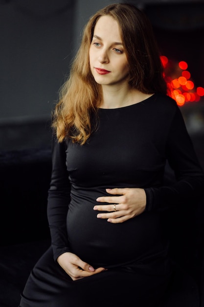 Young beautiful pregnant woman in black dress Pregnancy fashion look concept