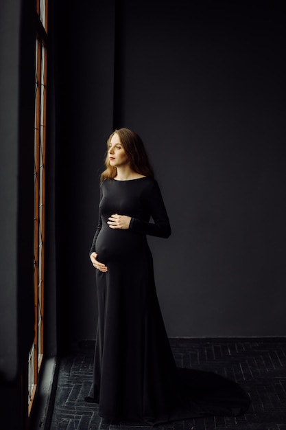 Young beautiful pregnant woman in black dress Pregnancy fashion look concept