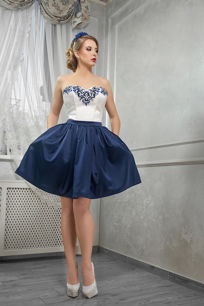 Young beautiful, pretty woman in  short blue-and-white dress, ha