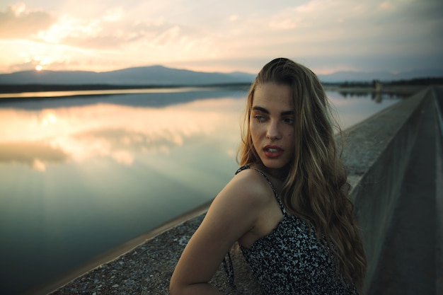 Young beautiful rebel woman on empty road at sunset