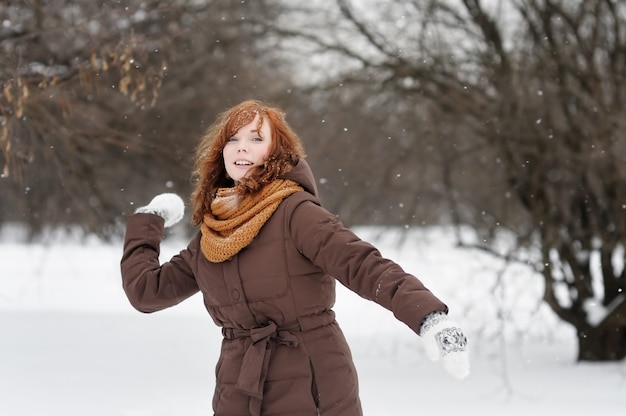 Young beautiful red haired woman having fun in winter  