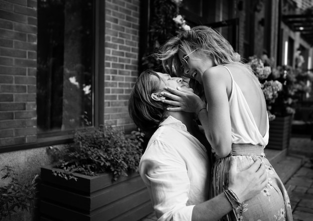 Young beautiful Sensual couple laughing, having fun on the street. Happy man and woman in love embrace. Black and white photo of Caucasian hugging models