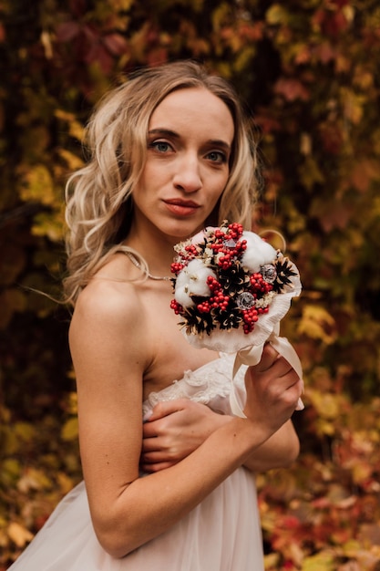 Young beautiful sexy girl blonde bride posing with a bouquet