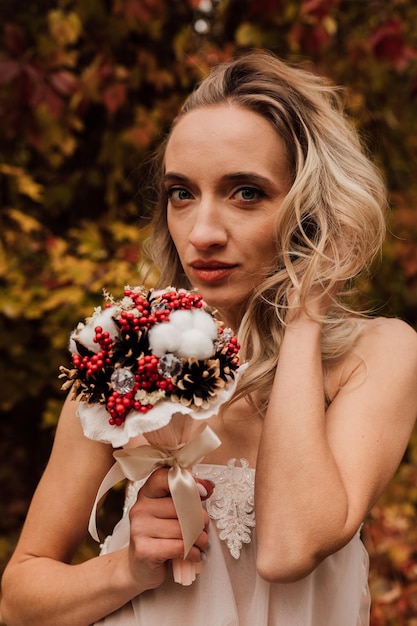 Young beautiful sexy girl blonde bride posing with a bouquet