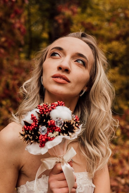 Young beautiful sexy girl blonde bride posing with a bouquet