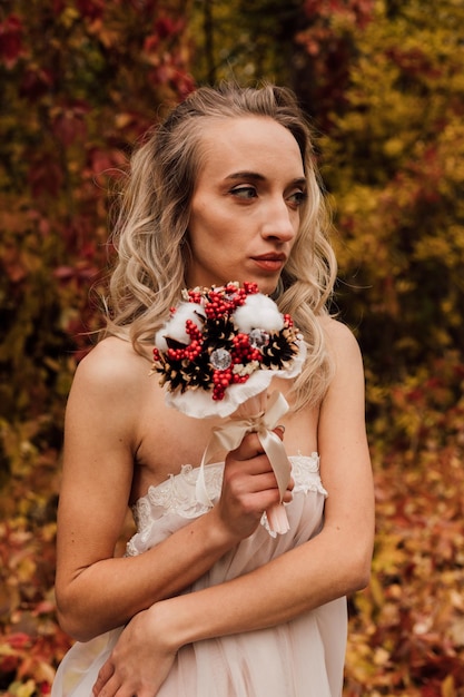 Young beautiful sexy girl blonde bride posing with a bouquet