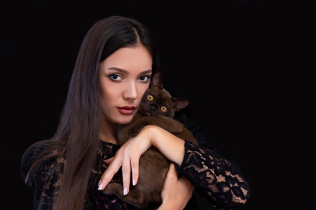 Young beautiful sexy woman with bright makeup with a cat in her hands