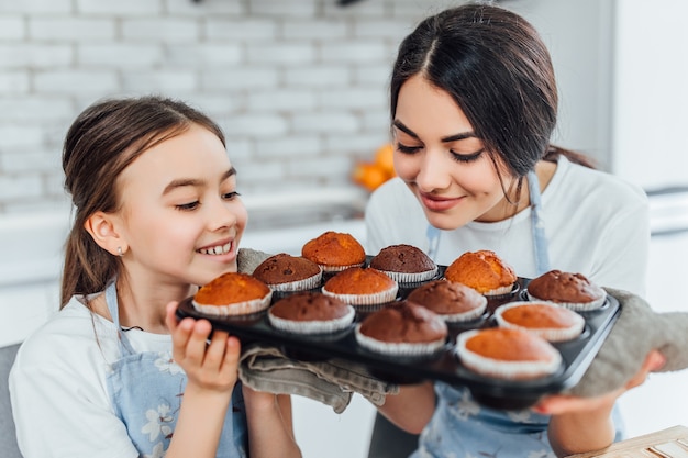 Young beautiful sisters with cupcakes