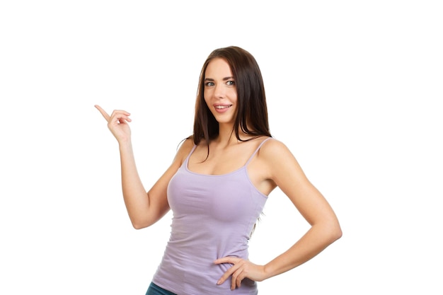 Young beautiful smiling girl isolated on a white background points his fingers at the place for promotions offers or advertising