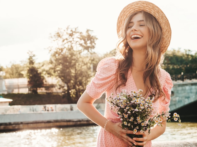 Young beautiful smiling hipster woman in trendy summer sundress