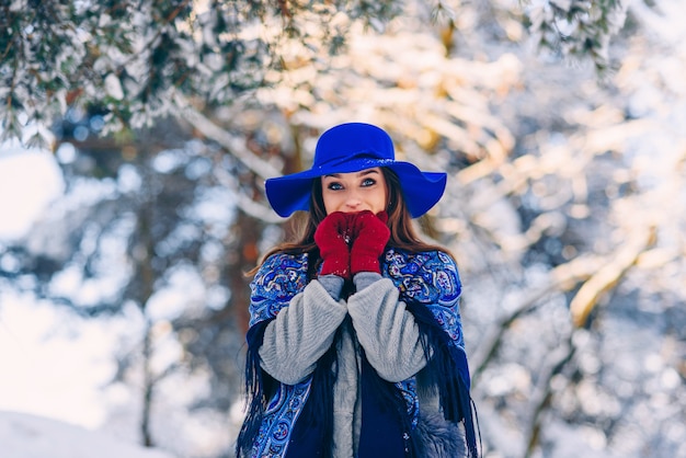 Young beautiful stylish woman in blue hat and scarf walking in the park