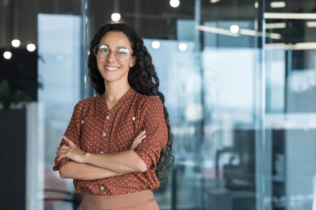 Young beautiful and successful hispanic businesswoman smiling and looking at camera female worker