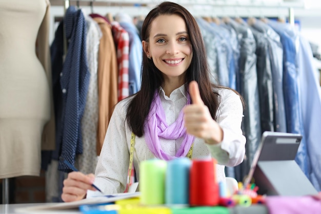 Young beautiful tailor woman showing thumbs up