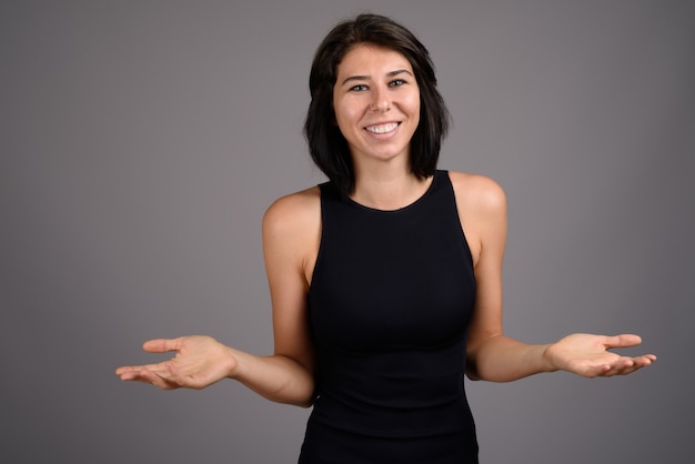 Young beautiful woman against gray background