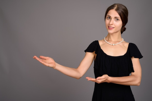 Young beautiful woman against gray wall