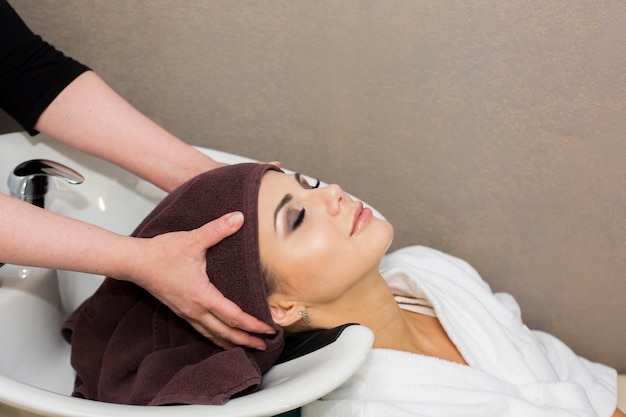 Young beautiful woman in bathrobes enjoying healthy procedure in wellness center