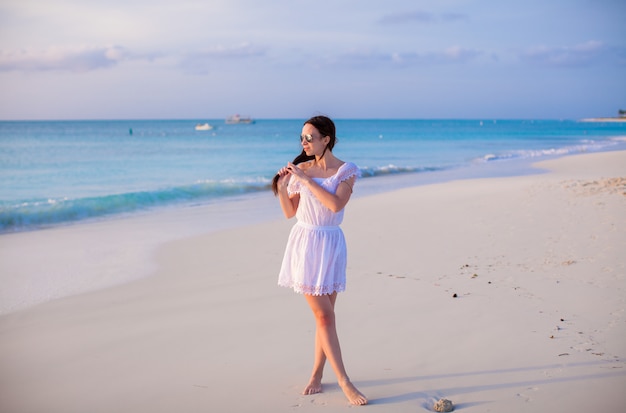 Young beautiful woman on beach during her summer vacation