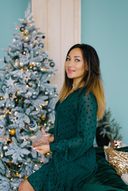 Young beautiful woman in camera makeup and hair styling with a hoop of a Christmas tree