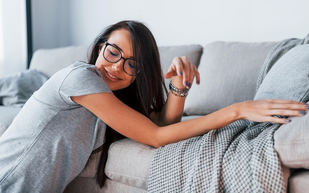 Young beautiful woman in casual clothes leaning on the bed at home.