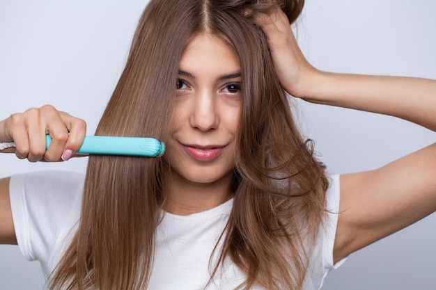 Young beautiful woman combing her hair in living room