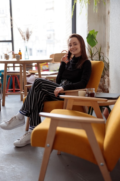 Young beautiful woman in cozy modern cafe