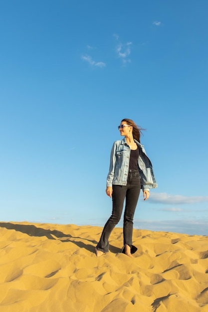 Young beautiful woman among the desert Barkhan Sarykum in autumn timeRepublic of Dagestanoctober 2022