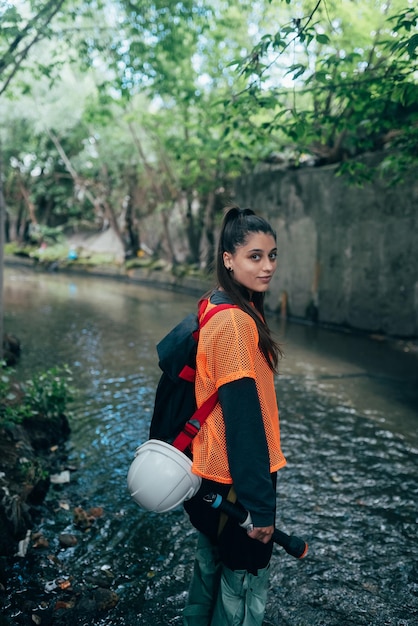 Young beautiful woman digger walks along the rain collector