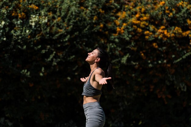 Young and beautiful woman doing gymnastics in the garden of her house on a sunny day yoga diet healt