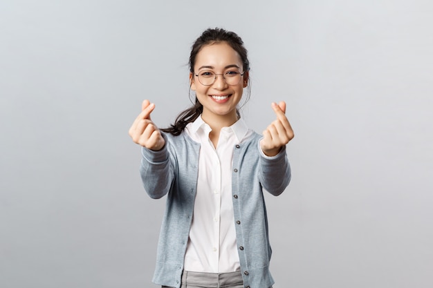 Young beautiful woman doing heart gesture with fingers