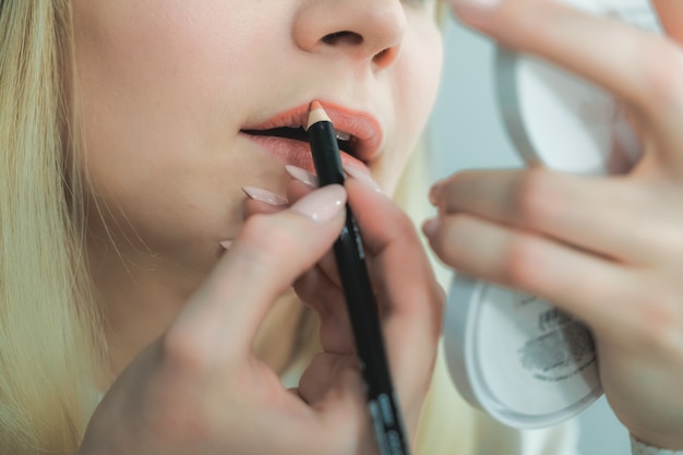 Young beautiful woman doing make-up