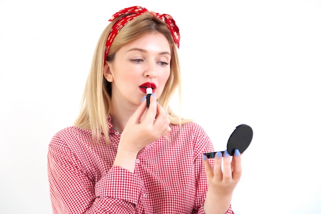 Young beautiful woman doing makeup on white