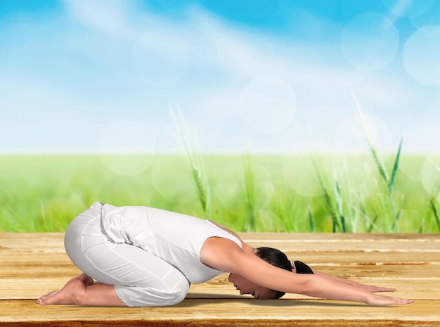 Young beautiful woman doing Yoga on background