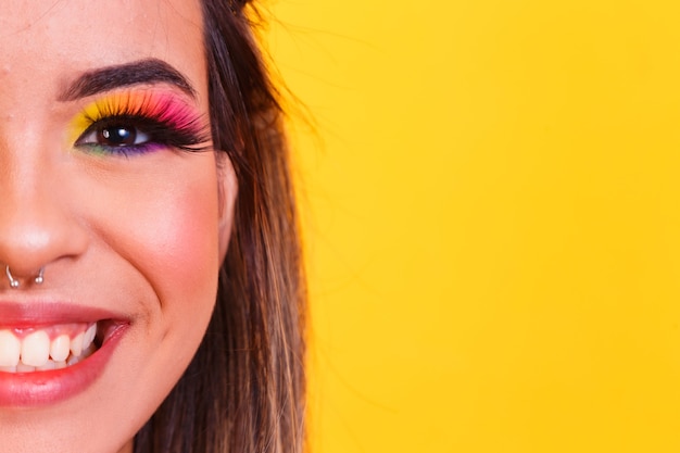 Young beautiful woman dressed for carnival and colorful makeup