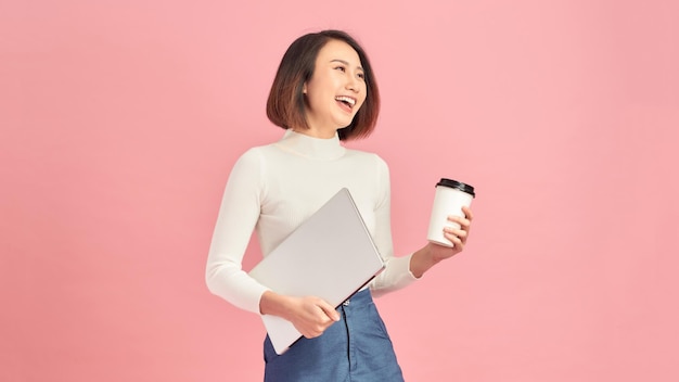 Young beautiful woman drinking coffee holding clipboard isolated over pink background