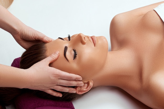 Young beautiful woman enjoying anti-aging facial massage