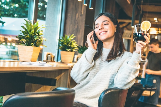 Young beautiful woman enjoying a glass of glint wine with eyes closed