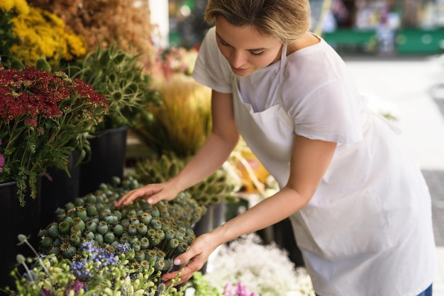 Young and beautiful woman florist working in her little flower shop